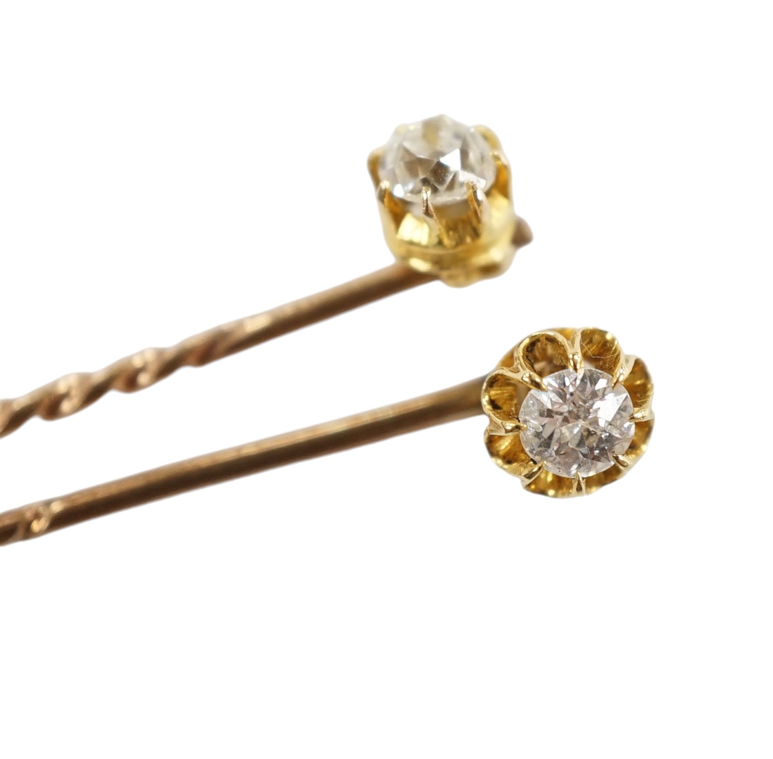 Two early 20th century yellow metal and solitaire diamond set stick pins, 65mm and a dress stud. Condition - fair to good